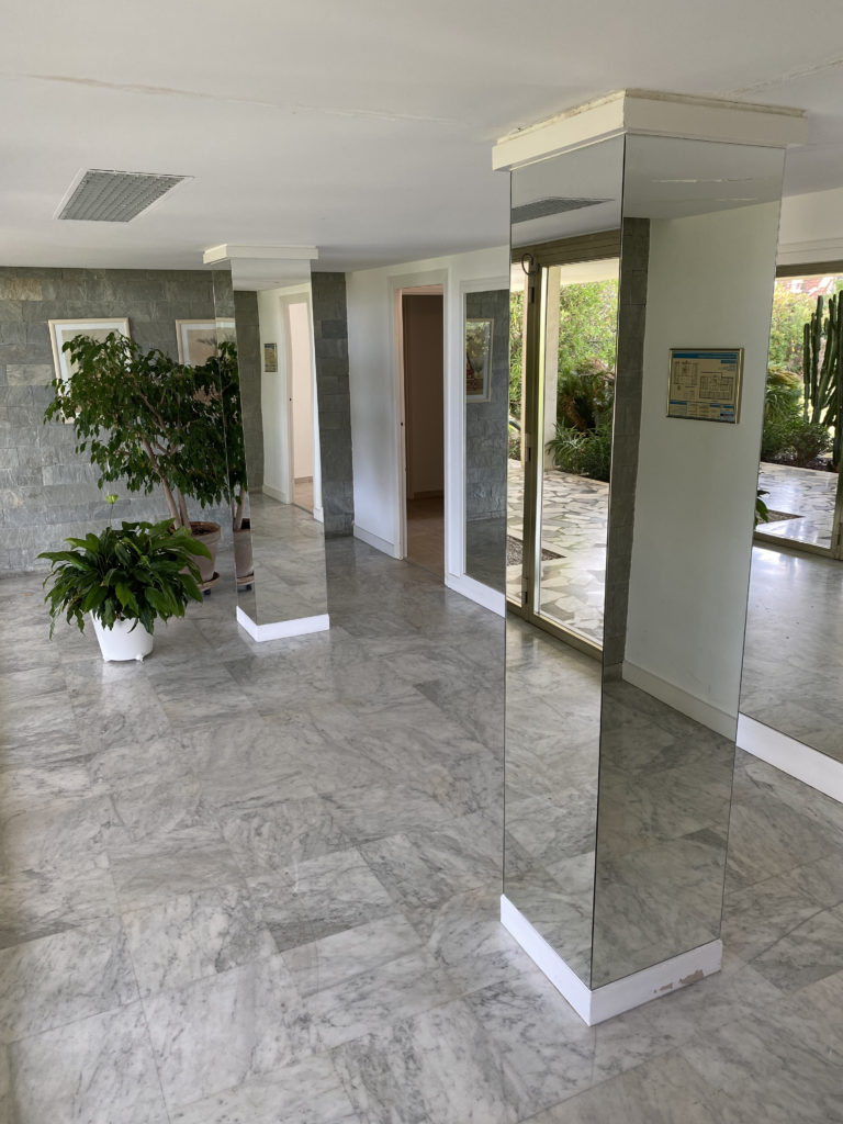 Habillage en miroir de piliers dans un hall d'immeuble