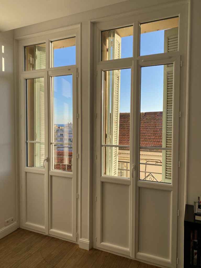 Porte-fenêtre en PVC blanche avec croisillon intégré dans le verre et sous-bassement plein