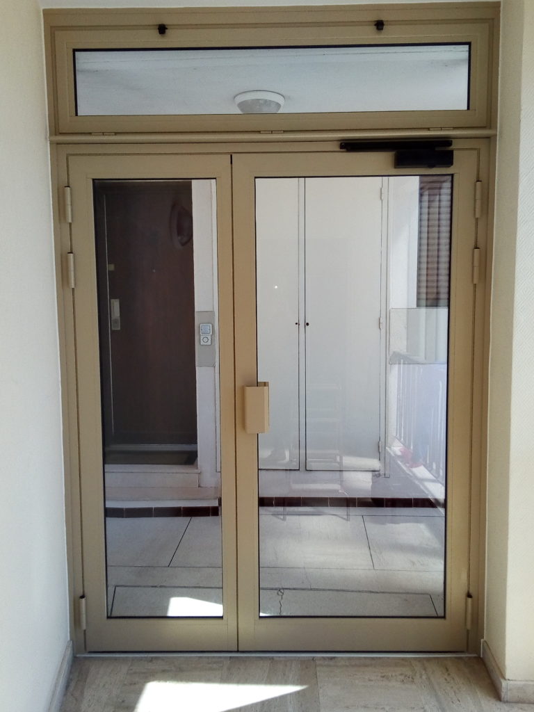 Porte d'entrée d'immeuble avec imposte en aluminium laqué gold beach